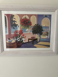 a framed painting of flowers hanging on a wall